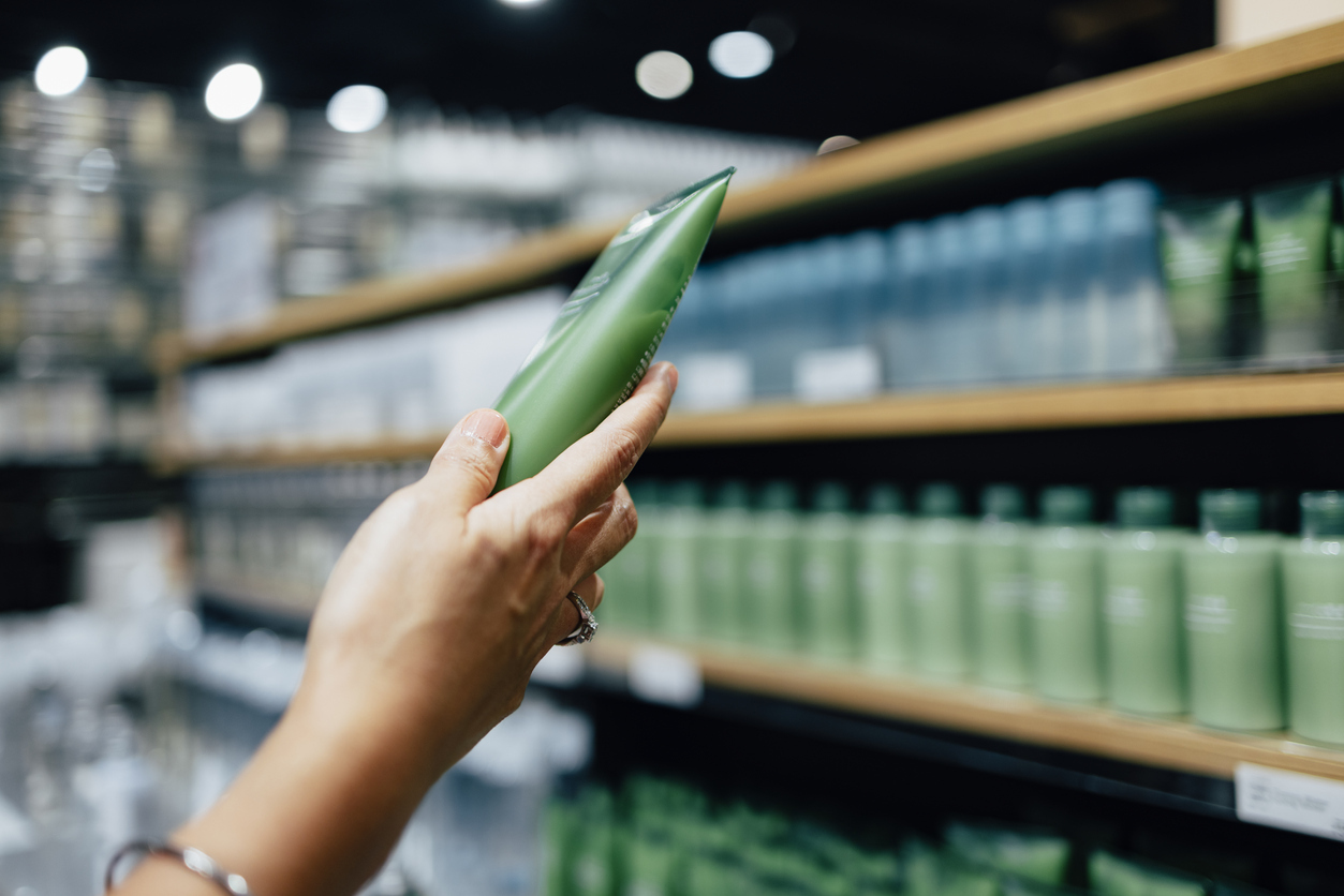 Close-up of handing choosing a beauty product from a shelf. 