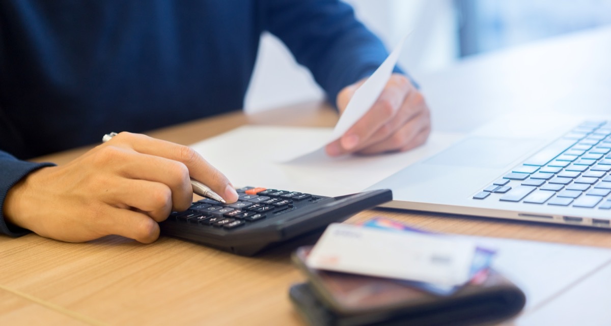 man using calculator to pay bills