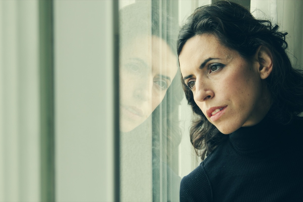 Woman looking out window during a lockdown