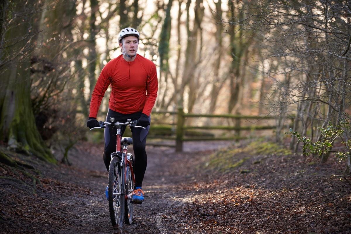 Man riding a bike not wearing a mask