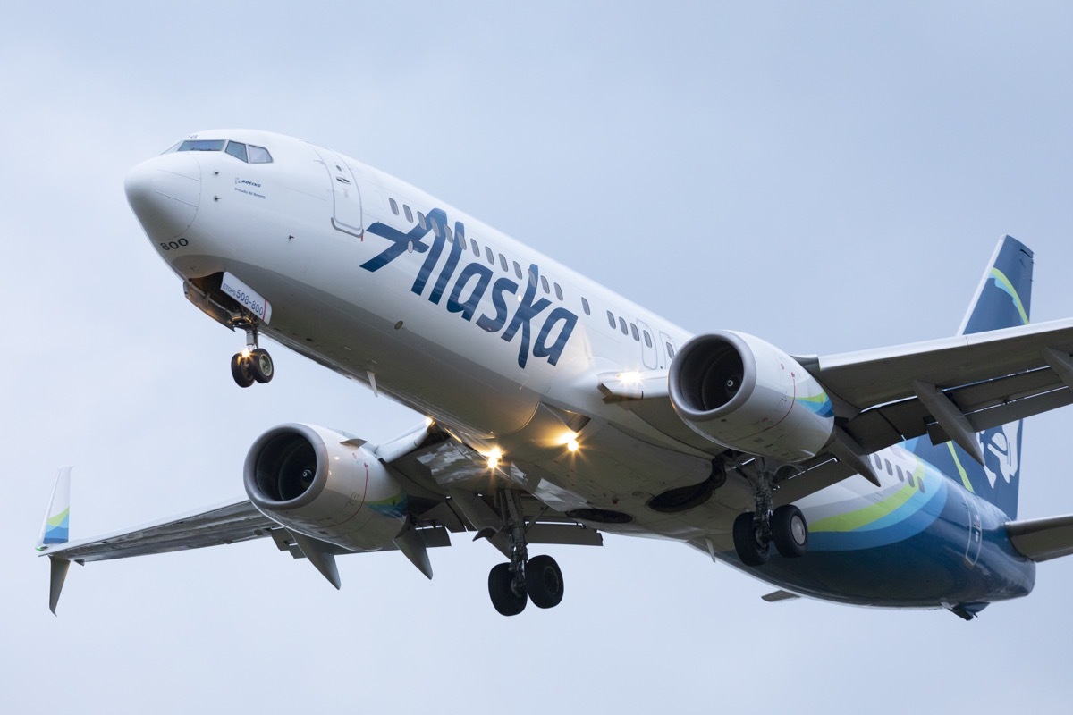 An Alaska Airlines Boeing 737 landing at Portland International Airport at dusk.