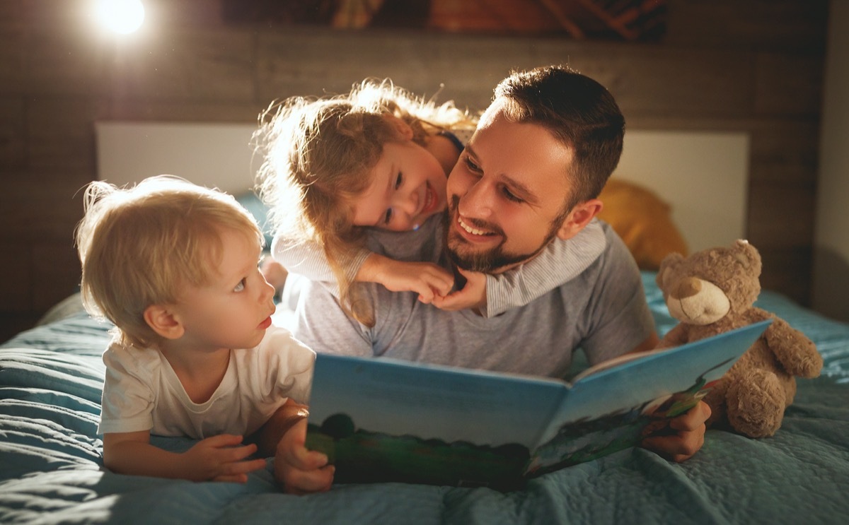 dad reads a bedtime story to his two kids