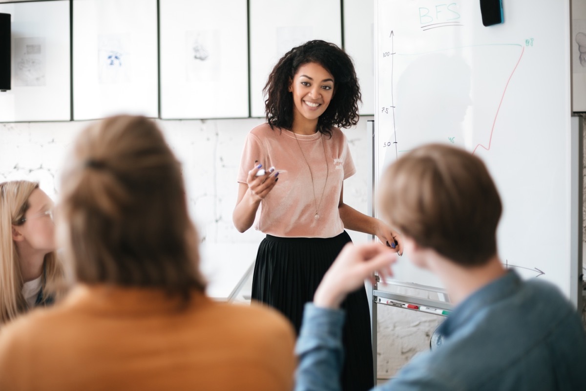 woman giving presentation to coworkers during meeting