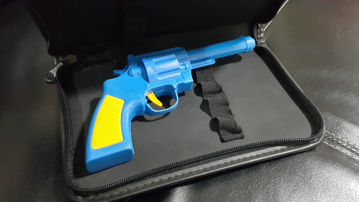 blue and yellow plastic gun in a briefcase