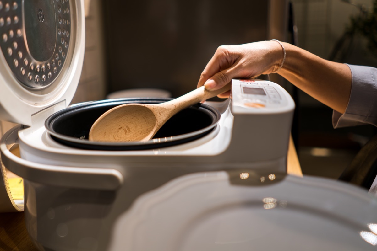 woman putting rice into a rice cooker