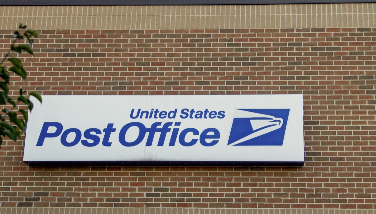 Exterior of United States Post Office with banner and logo.