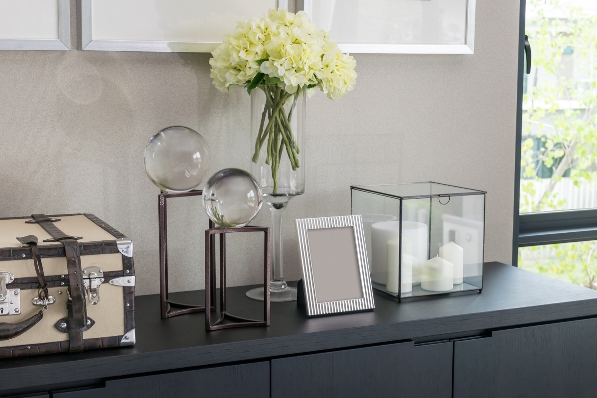 picture frames and candles on gray dresser