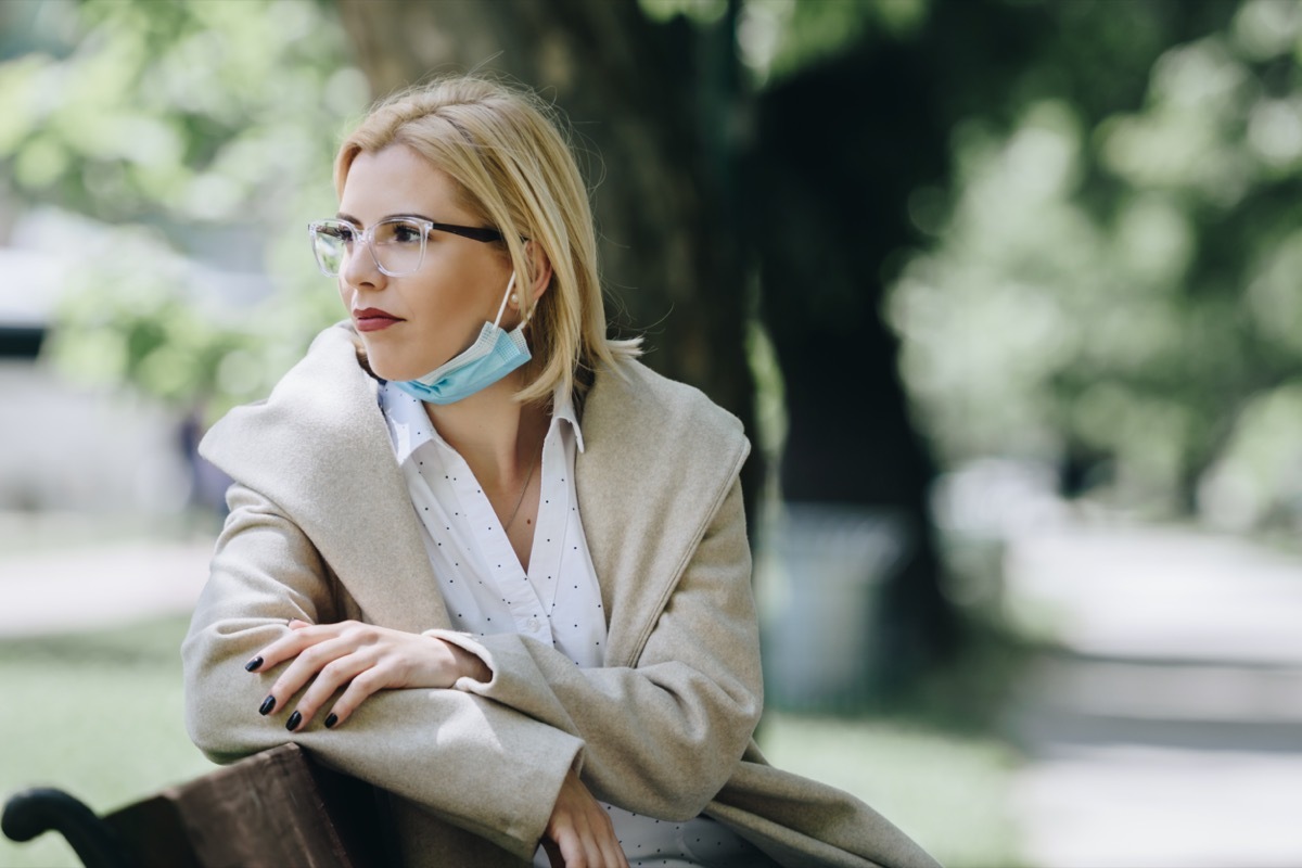 Woman with medical mask sitting