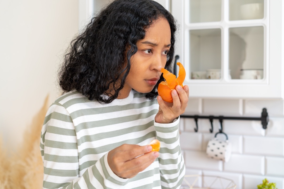 woman trying to smell orange