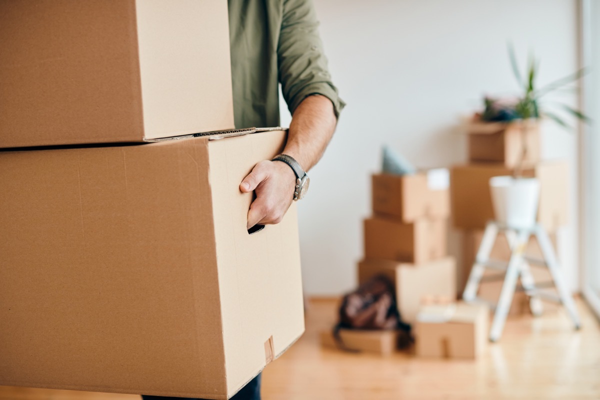 Close-up of a man with carton boxes moving into new home