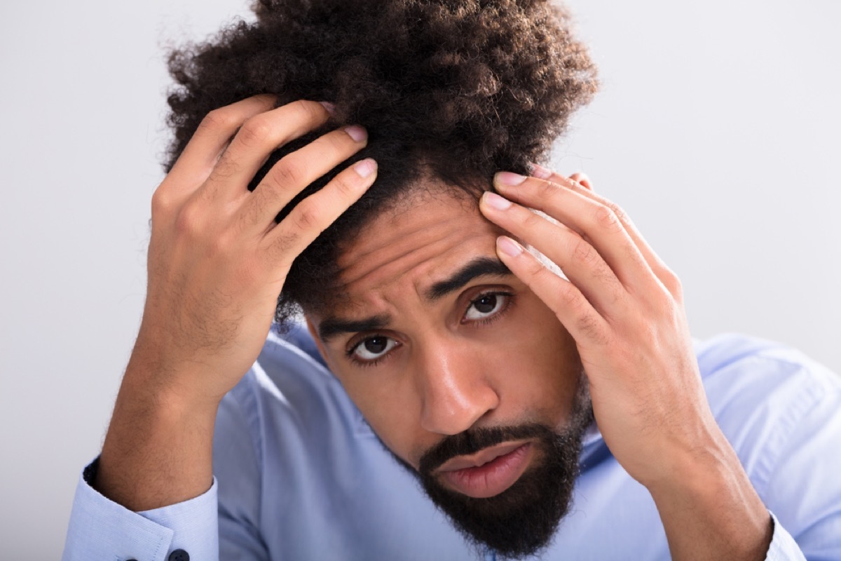 Young Black Man Examines Hair Loss