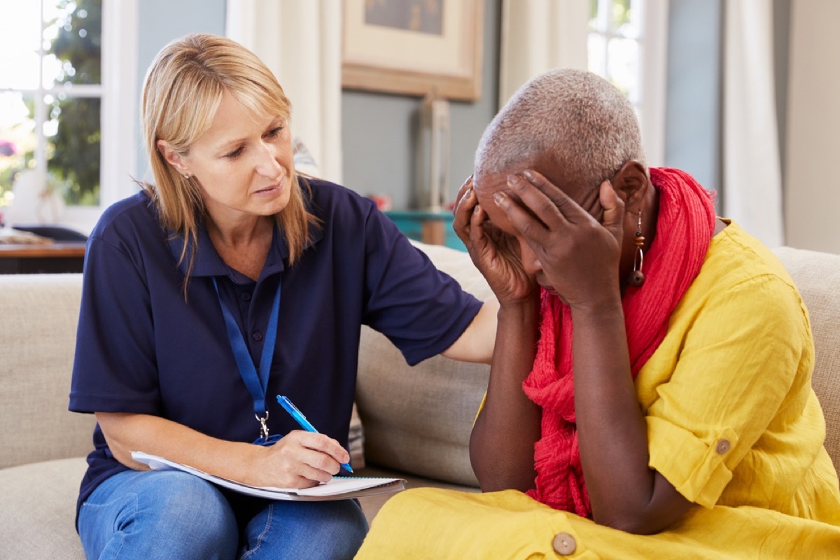 older black woman with head in hands talking to doctor