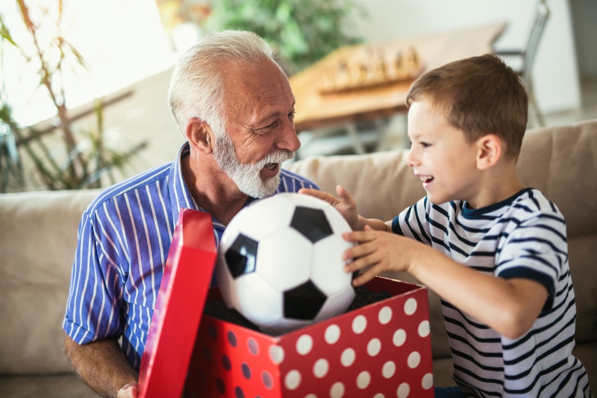 Grandpa giving grandson soccer ball