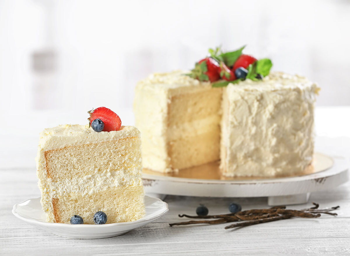 white cake slice out of cake with fruit on top of frosting