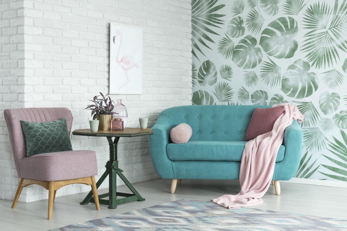 Room with fern wallpaper and exposed brick