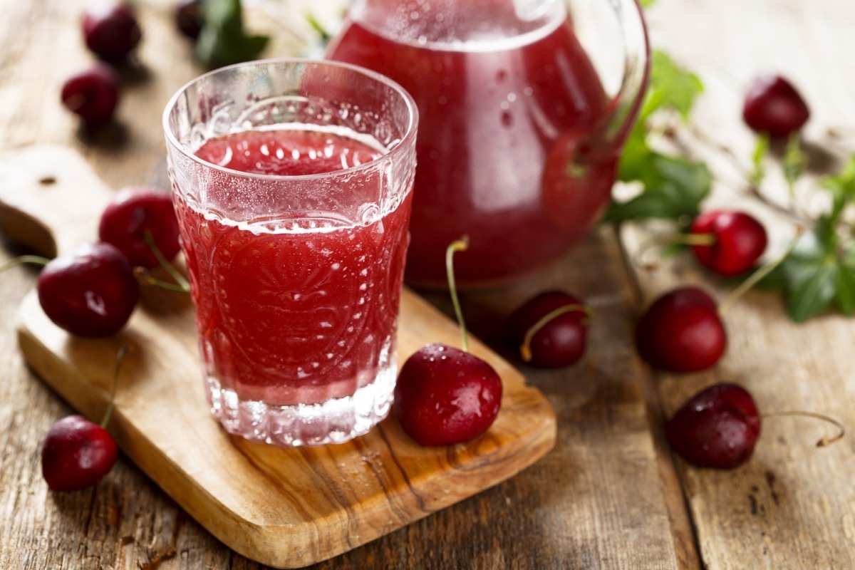 A glass and pitcher of cherry juice