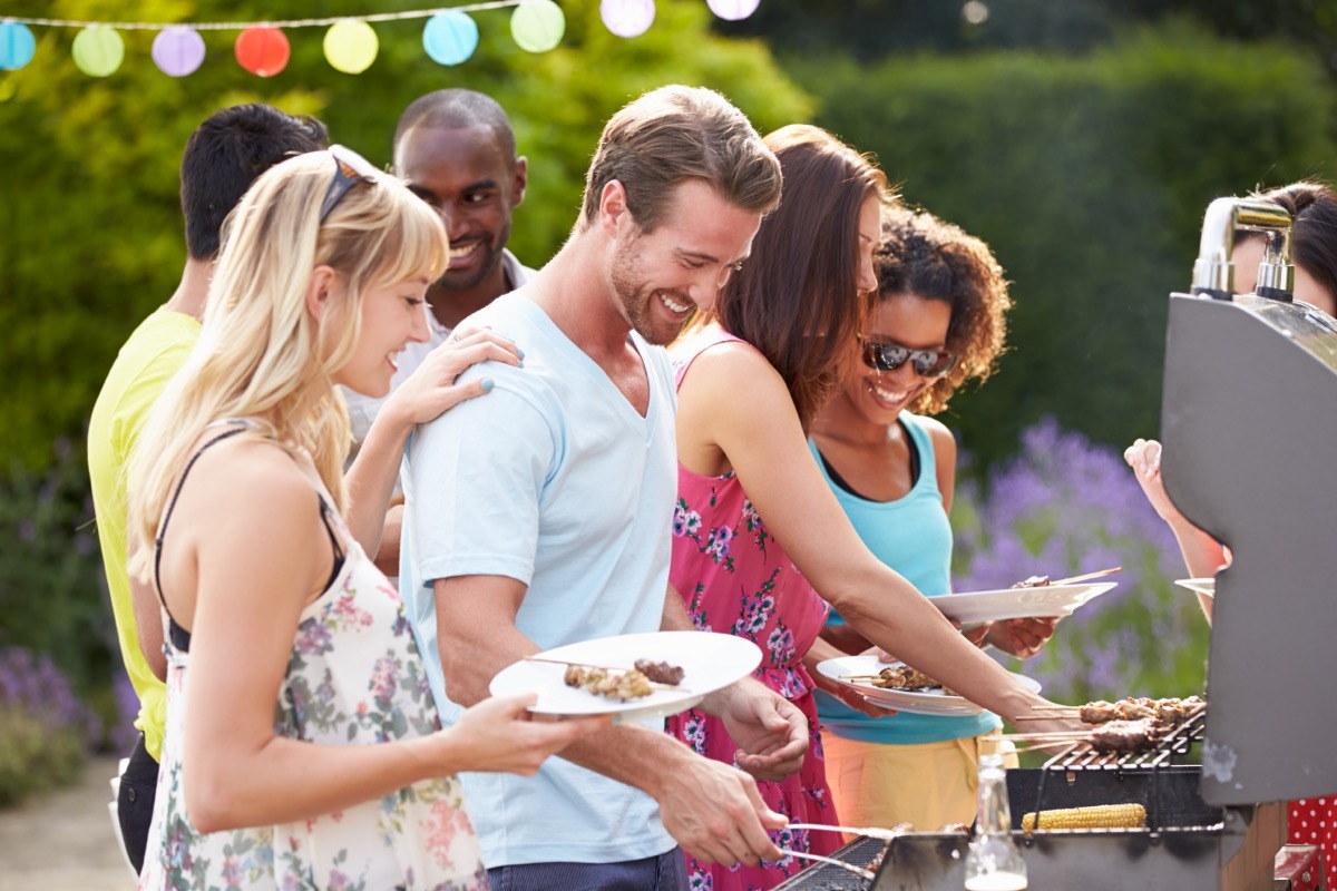 group of young friends grilling outdoors