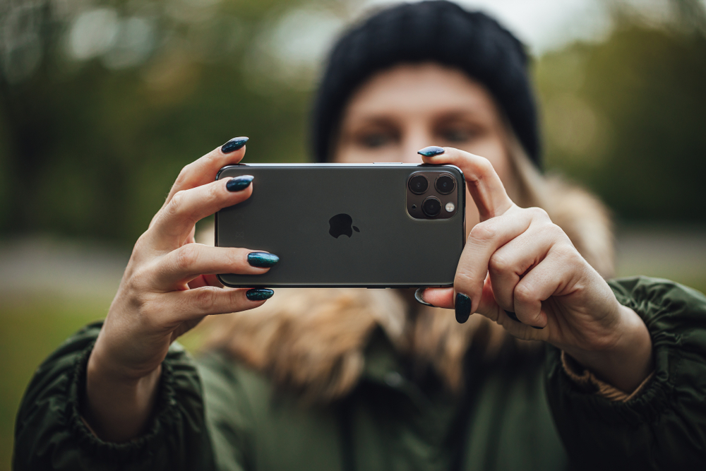 A person taking a photo using an iPhone