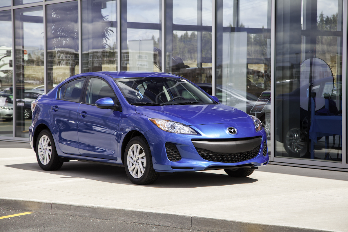 Blue Mazda 3 outside car dealership