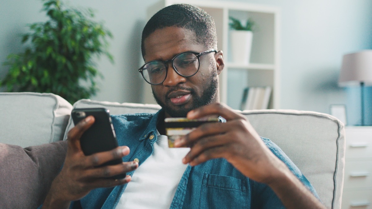 Man holding his credit card and his phone