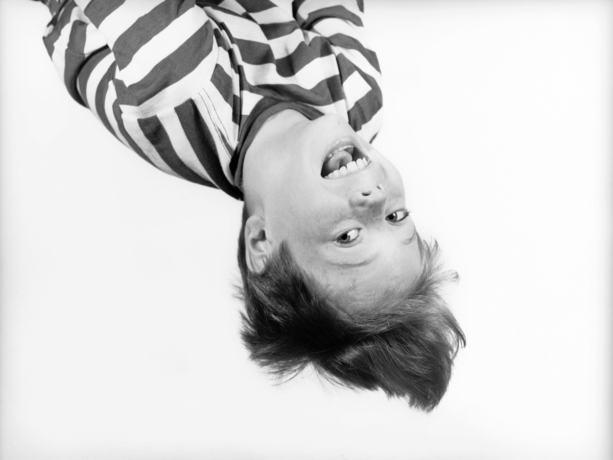 1950s BOY IN STRIPED T-SHIRT HANGING UPSIDE-DOWN