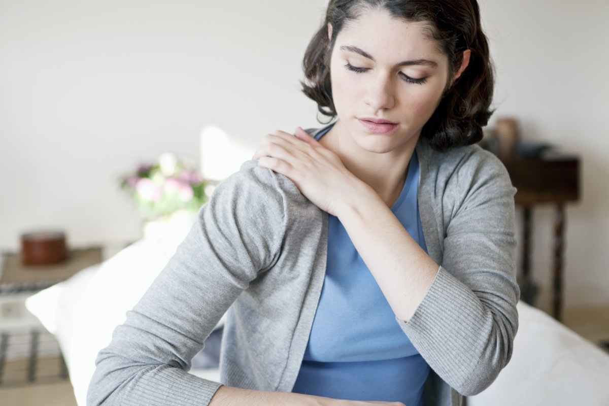 Woman touching her shoulder