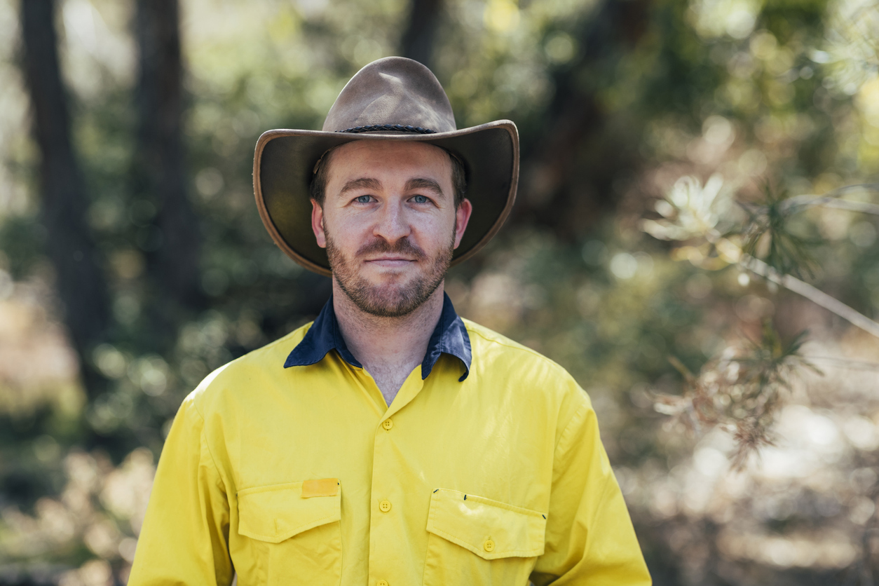 Portrait of a man looking at the camera wearing a bush hat and looking positive