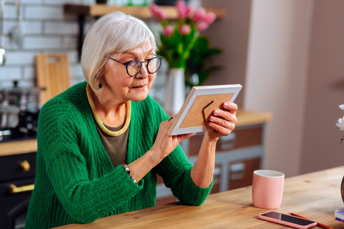 Older woman looking at a picture in a picture frame