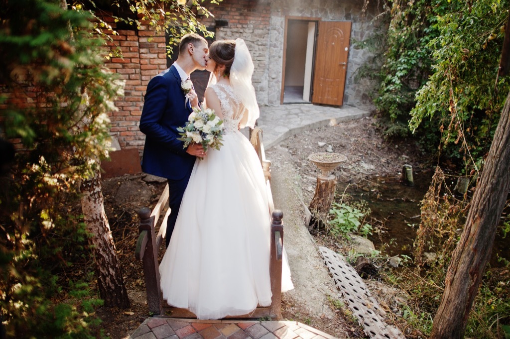 bride and groom kissing forest https://www.shutterstock.com/image-photo/bride-groom-go-home-along-road-1140990437?src=https://bestlifeonline.com/wp-content/uploads/sites/3/2018/07/bride-groom-kissing-forest.jpg?quality=82&strip=all