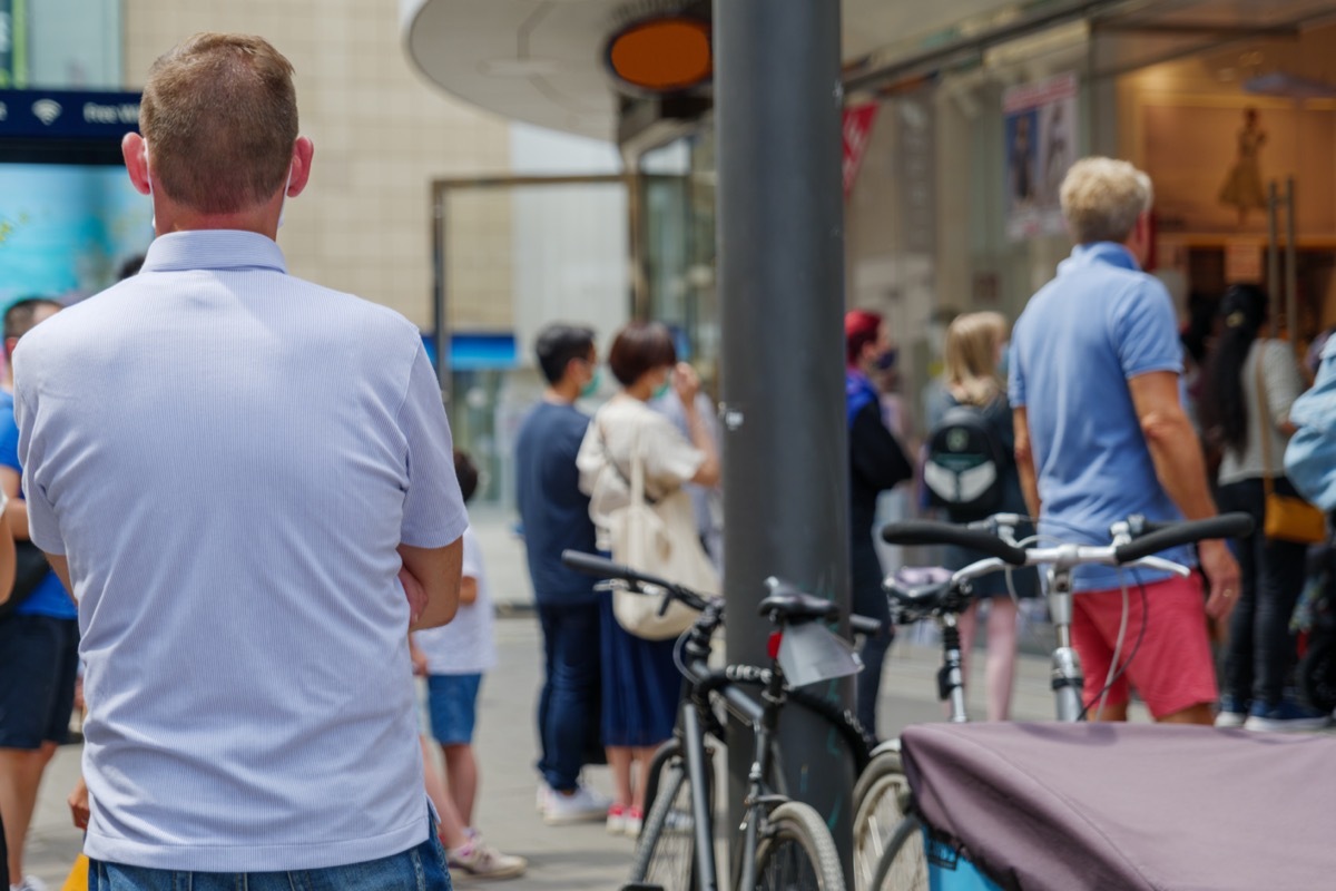 Selected focus view, man with face mask queue and wait for enter a shop on sidewalk