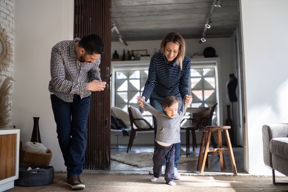 Father filming baby son's first steps