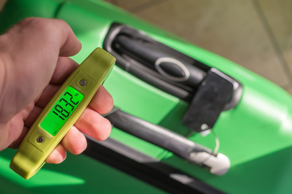 Weighing suitcase with a luggage scale