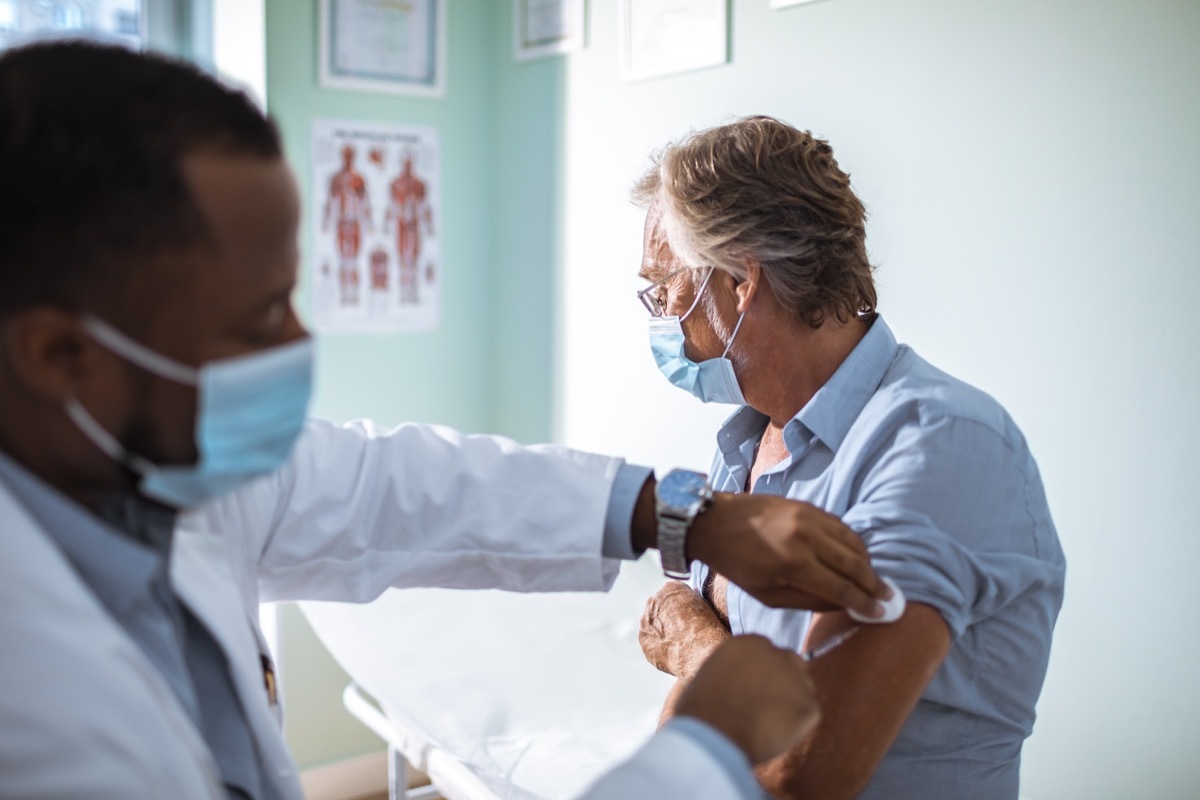 Close up of a mature man taking a vaccine in his doctors office