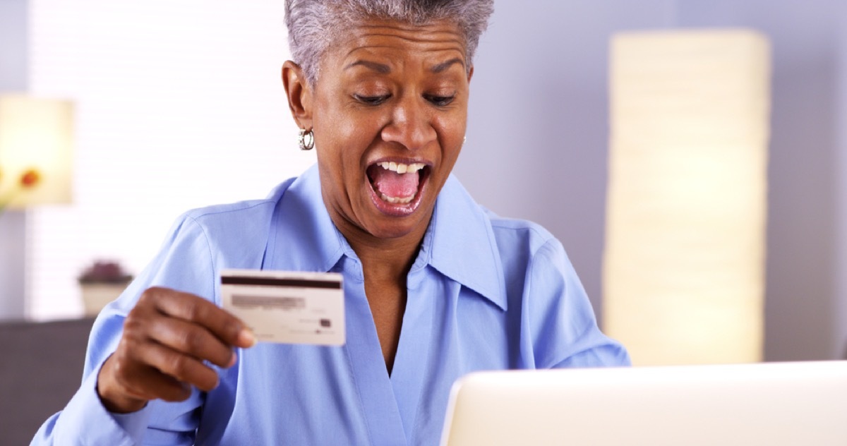 senior black woman at laptop with credit card in hand