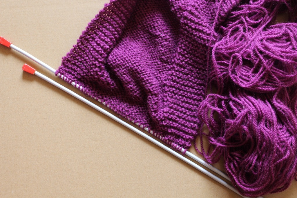 knitting needles and purple yarn