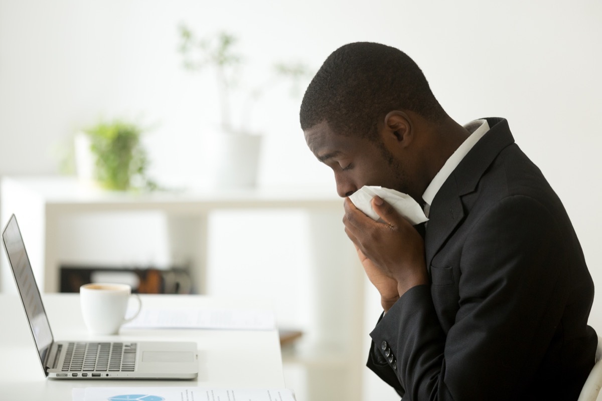 Man getting sick at his desk in his office