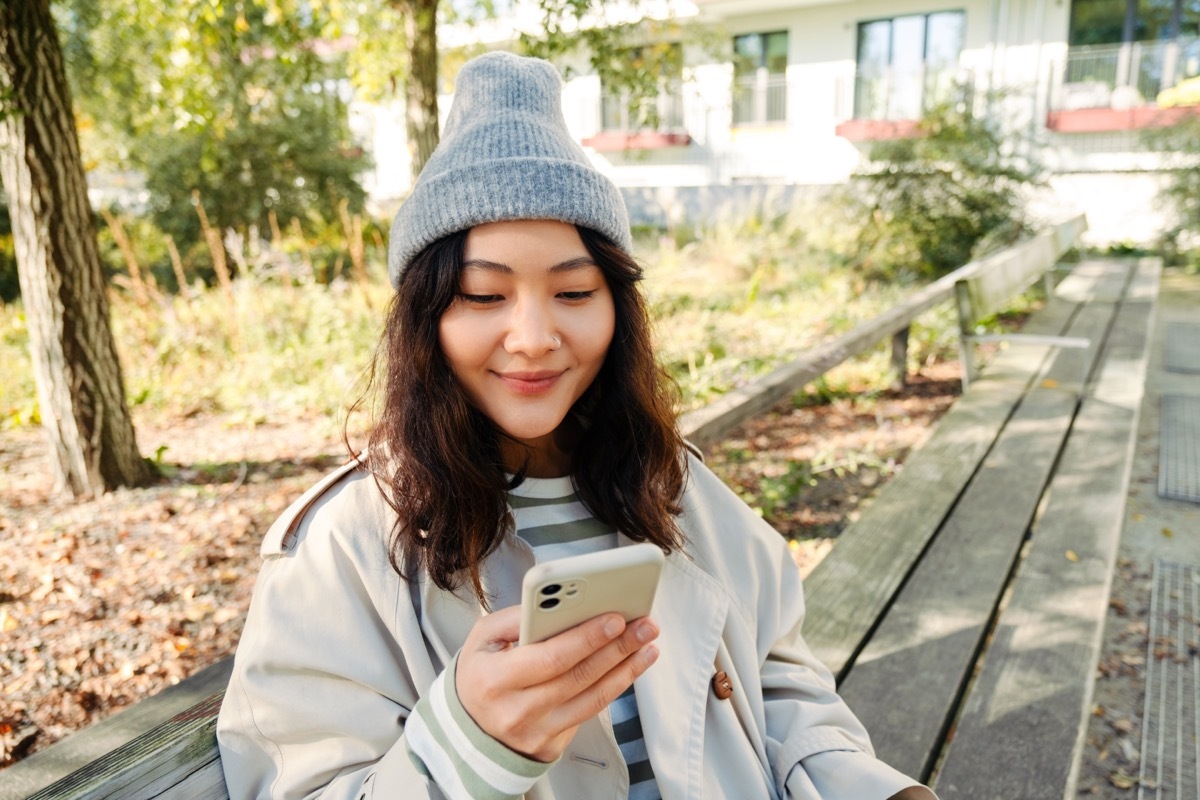 woman smiling looking at her phone