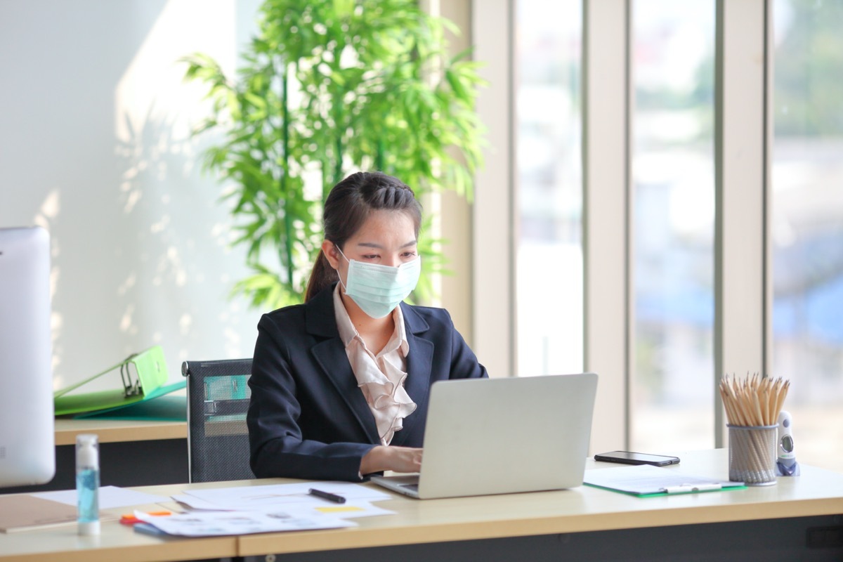 young asian woman wearing face mask at work