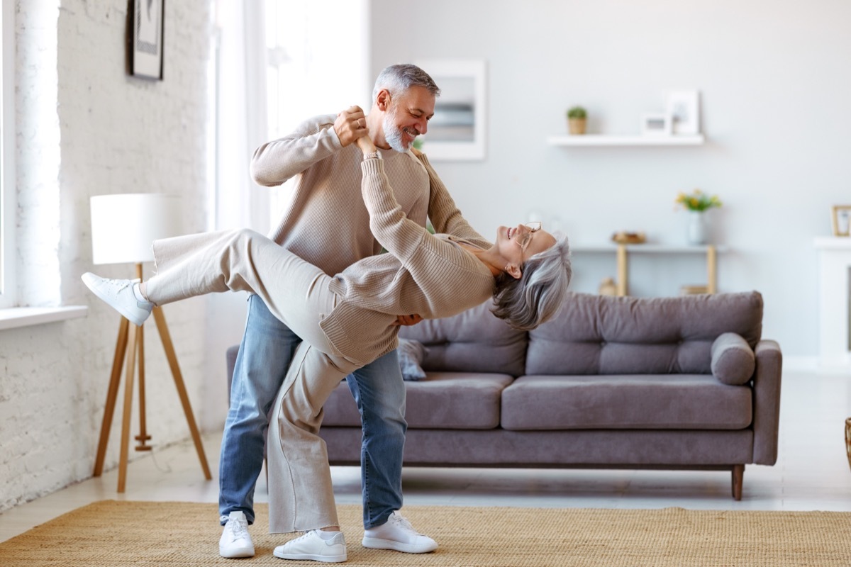 senior couple dancing in living room