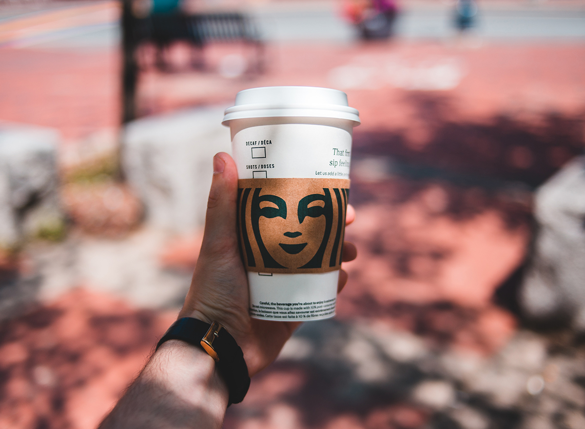 Man holding Starbucks cup outside