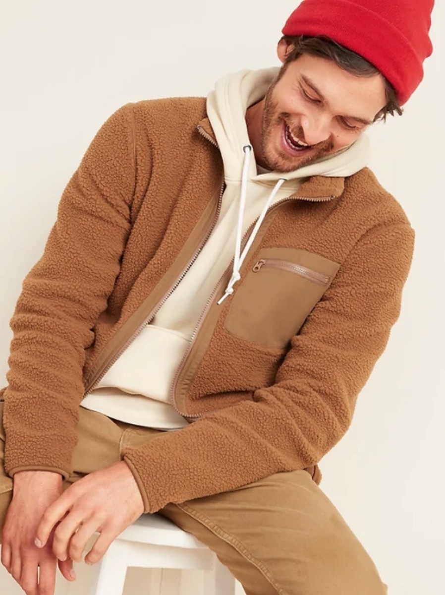 young man in red hat and brown fuzzy jacket