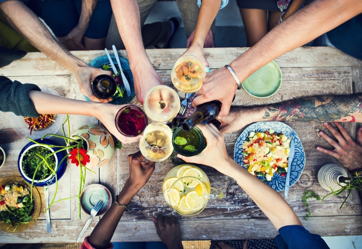 Close up of friends toasting their drinks over a table