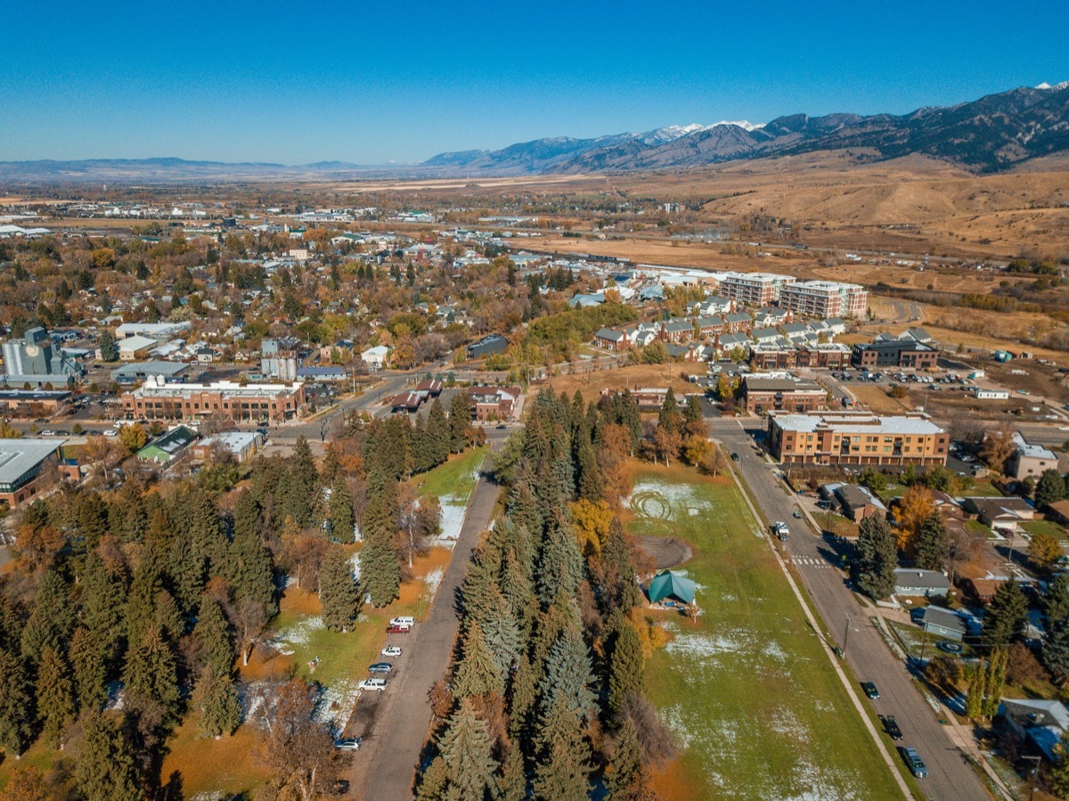 An aerial view of the brightly colored autumn trees in Lindley Park and a view of downtown Bozeman, Montana in Fall.